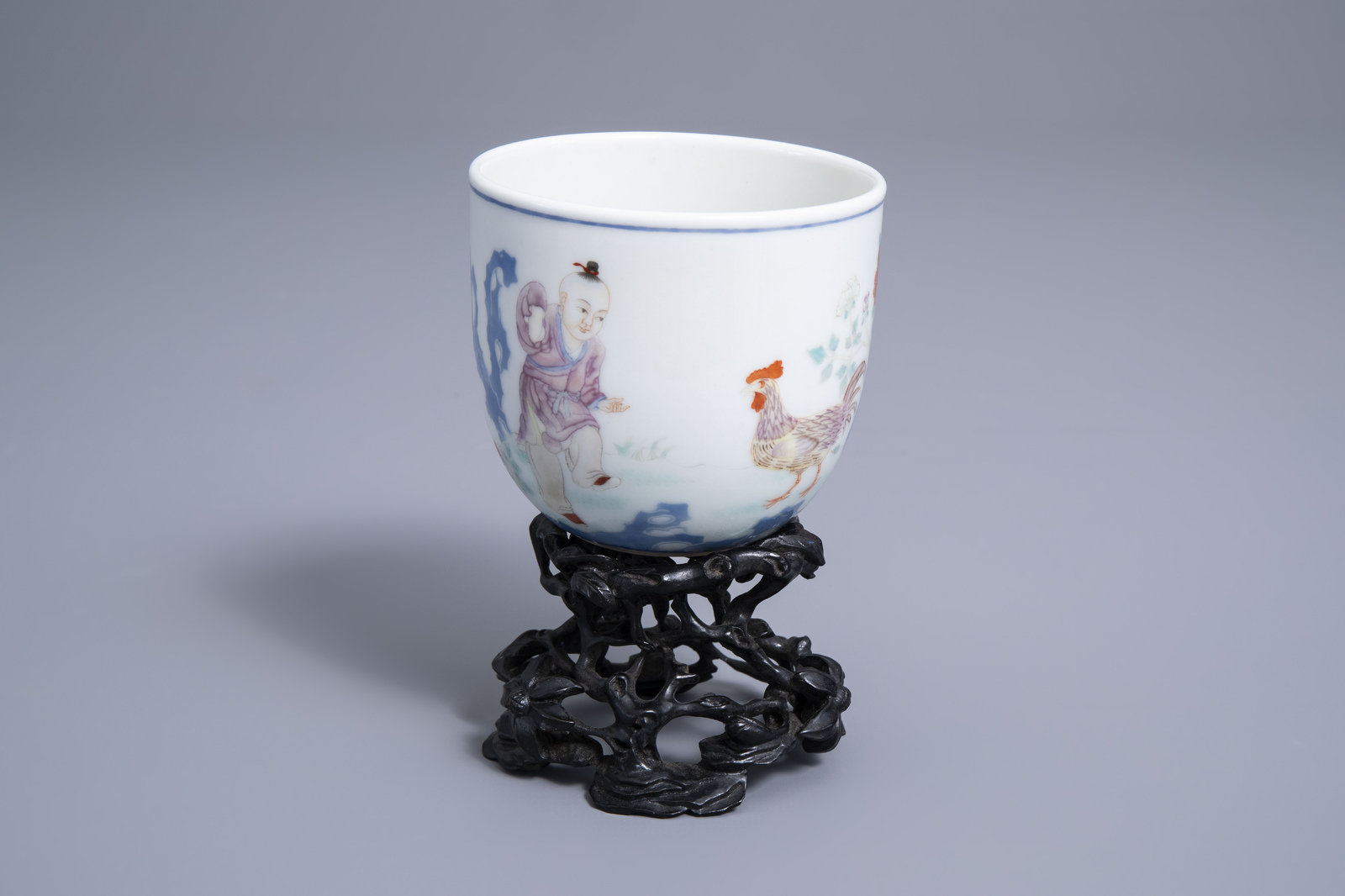 A Chinese famille rose 'boy and rooster' cup on wooden stand, Qianlong mark, 20th C.