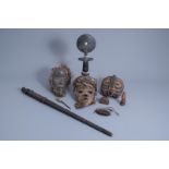 Three African wooden masks, votive objects and a cane, 20th C.