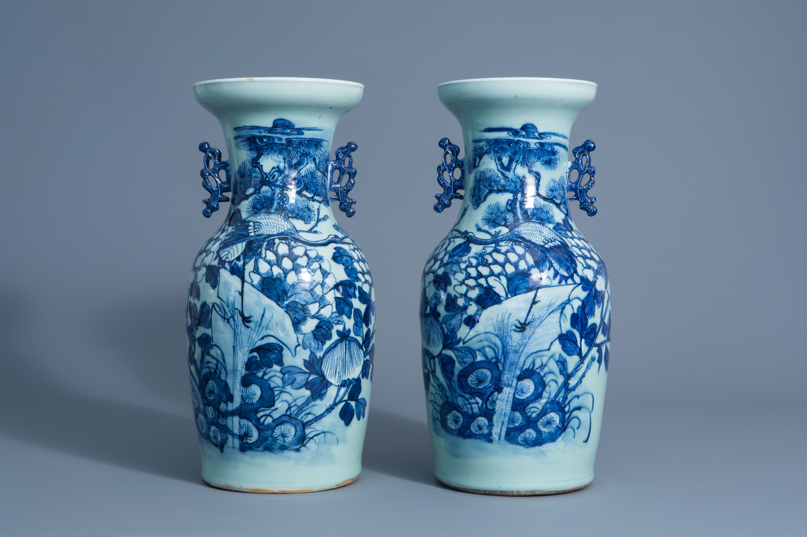 A pair of Chinese blue and white celadon vases with cranes on a rock, 19th C.