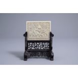 A Chinese reticulated celadon jade plaque on wooden stand, 19th C.