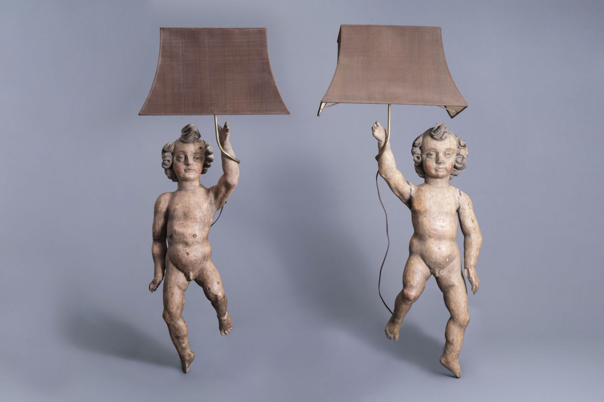 A pair of carved and polychrome painted wooden angels mounted as lamps, probably Southern France, ca