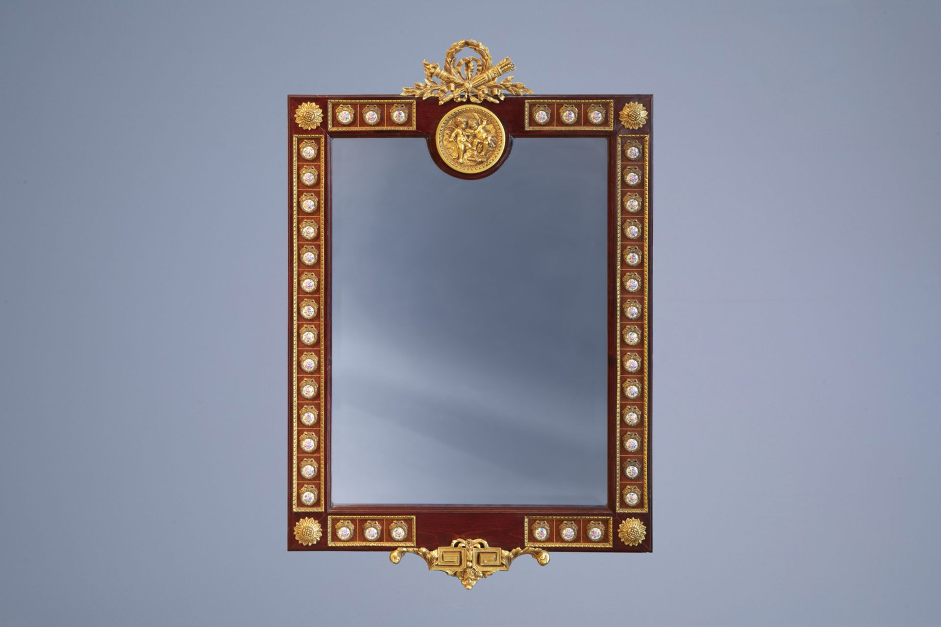 A French wooden mirror with gilt mounts and plaques with floral design in the Svres manner, 20th C.