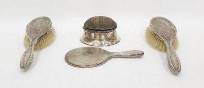 Two silver-backed dressing table brushes, a dressing table mirror and a pin cushion (4)