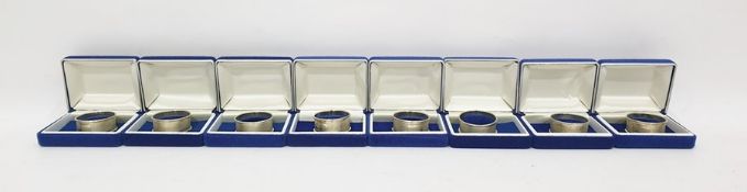 Set of eight individually cased white metal napkin rings
