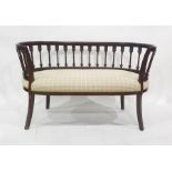 Two seater settee, the curved top rail above wheatsheaf style supports, ovoid seat and swept