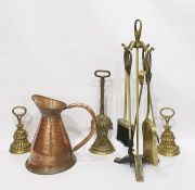 Three brass doorstops, fireside companion set and a copper ewer