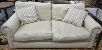 Modern cream fabric two seater sofa, with two scatter cushions