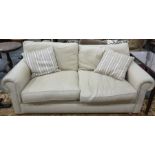 Modern cream fabric two seater sofa, with two scatter cushions