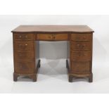 Modern serpentine fronted mahogany desk with nine assorted drawers, bracket feet