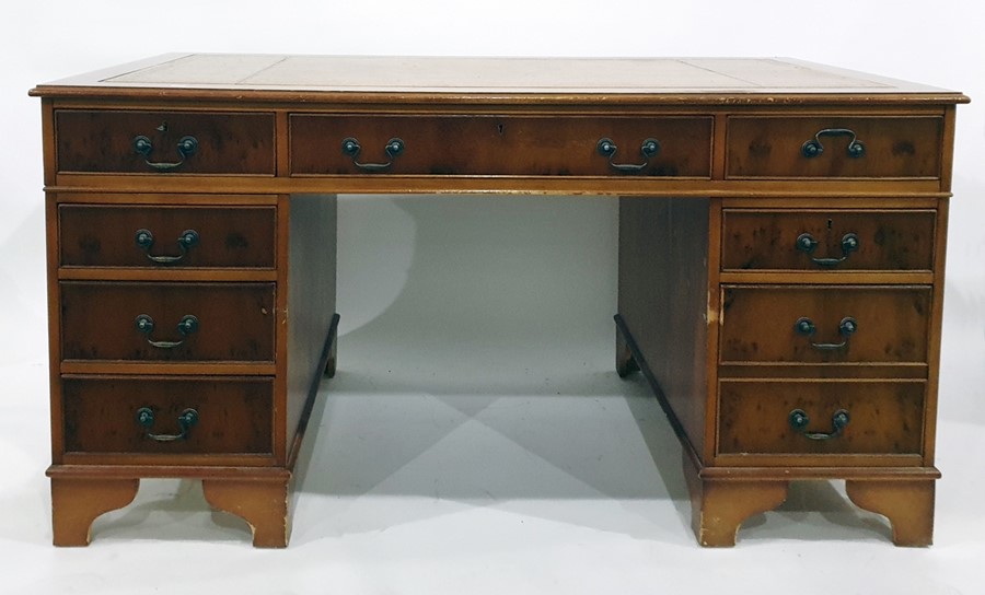 20th century yew pedestal desk with brown leather inset top above the nine assorted drawers, bracket