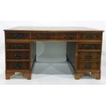 20th century yew pedestal desk with brown leather inset top above the nine assorted drawers, bracket