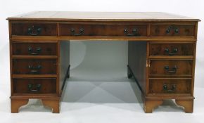 20th century yew pedestal desk with brown leather inset top above the nine assorted drawers, bracket