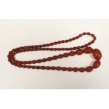 String of red amber-coloured graduated oval beads