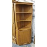 Light coloured Ercol corner display cabinet, three shelves above cupboard door