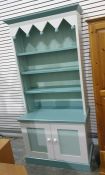 Painted dresser with assorted open shelves above two cupboard doors, plinth base, one further