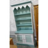 Painted dresser with assorted open shelves above two cupboard doors, plinth base, one further