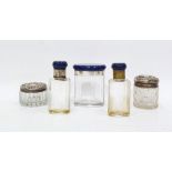 Two silver-topped glass dressing table bottles and three hardstone, possibly lapis lazuli topped,
