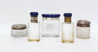 Two silver-topped glass dressing table bottles and three hardstone, possibly lapis lazuli topped,