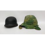 World War II German helmet together with one further helmet in camouflage cover