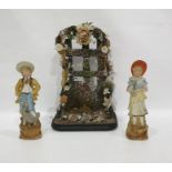 Pair late 19th century tinted bisque figures of boy and girl with birds and a floral applied