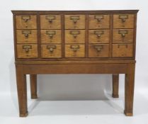 Early 20th century oak bank of fifteen short filing drawers raised on stand, 85 x 76cm
