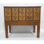 Early 20th century oak bank of fifteen short filing drawers raised on stand, 85 x 76cm