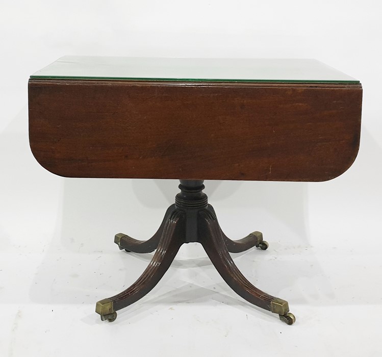 19th century mahogany Pembroke table on single pedestal to four reeded swept legs, brass caps and