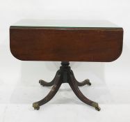 19th century mahogany Pembroke table on single pedestal to four reeded swept legs, brass caps and