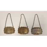 Set of three silver wine labels "Brandy", "Sherry" and "Gin" with rococo scallopshell borders,