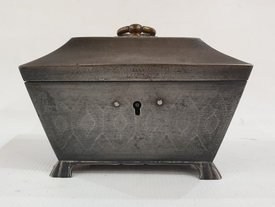 White metal sarcophagus-shaped box, the top with brass ring handle and opening to reveal red