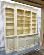 Yellow painted bookcase in the Georgian manner with moulded pediment above the break front, with