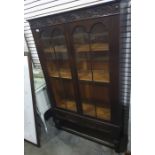 20th century oak display cabinet with two glazed doors enclosing shelves, turned supports and