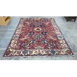 Pink ground rug decorated in blues, creams, browns