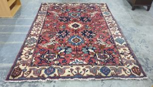 Pink ground rug decorated in blues, creams, browns