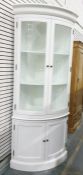 20th century white-painted bowfront corner display cabinet, the moulded cornice above two glazed