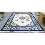 Blue and cream large Chinese washed wool rug with central motif of flowers surrounded by other