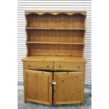 Pine dresser with open shelves above two drawers and two cupboard doors