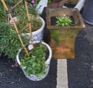 Two white and blue ceramic planters containing wall flowers and violas and one reclaimed waisted