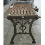 Cast iron garden table with woven lattice style decoration to the top with two cast patterned ends