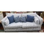 Three-seater sofa with white ground foliate patterned upholstery with scatter cushions  Condition