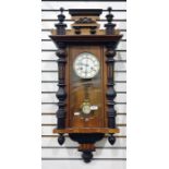 Vienna regulator style wall clock in elaborately carved case with brass bezel face, white enamelled,