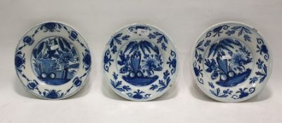 Set of three Delft shallow dishes, each painted in underglaze blue with exotic plants, floral and