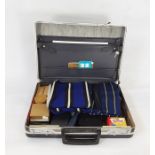 Metal attache case containing college scarves, notebooks, stud box with studs, bow ties, etc