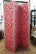 Three fold screen, covered in red damask, with red and gold braid detail