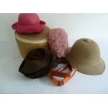 A Pith helmet, cardboard hat box , three hats and an orange leather belt.