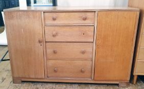 20th century oak sideboard, probably by Gordon Russell, with four central drawers, one bearing