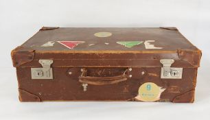 Vintage leather suitcase bearing luggage labels