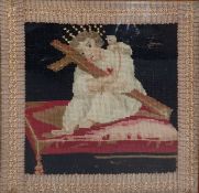 Victorian woolwork embroidery picture of the infant Jesus embracing a cross, seated on a cushion,