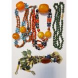 Two bead necklaces, each having large amber-coloured beads amongst others, green hardstone bead
