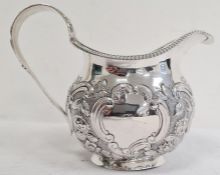 George IV silver milk jug, having gadrooned everted rim, ornate floral cornucopia decorated